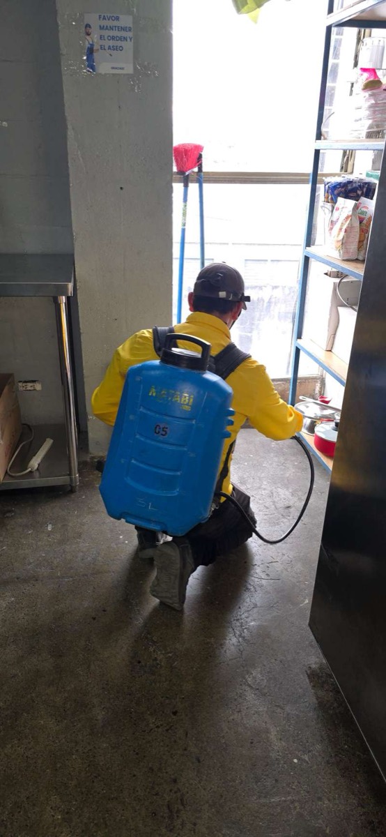 Técnico de EcoPlagas aplicando producto en un local comercial