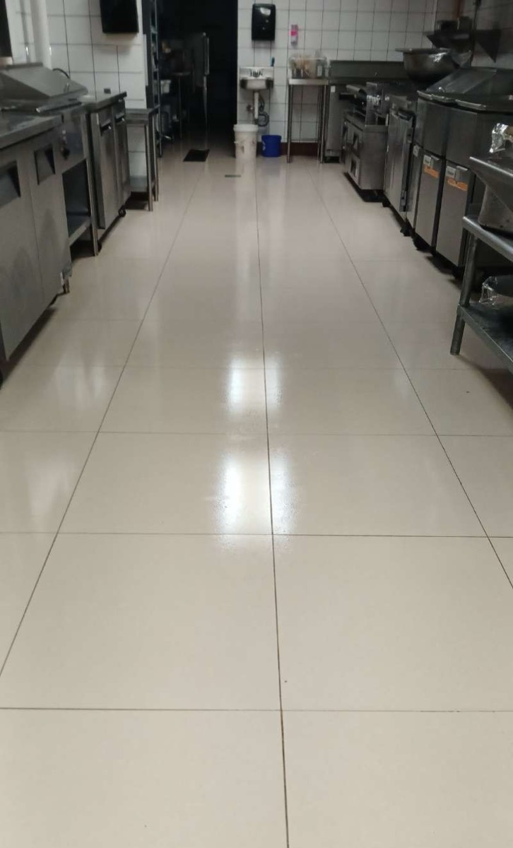 Piso de cocina comercial limpio tras servicio de control de plagas